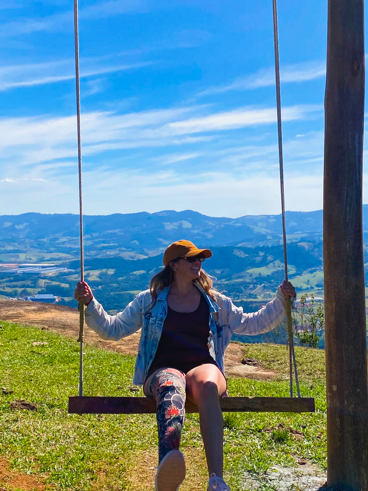 Daiane em um balanço com paisagem ao fundo